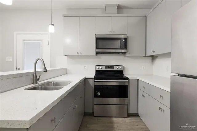 a kitchen with white cabinets stainless steel appliances and sink