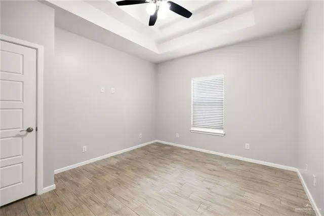 an empty room with a window and a ceiling fan