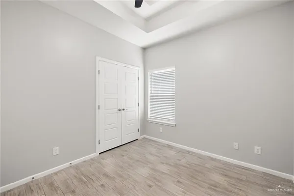 an empty room with windows and cabinet