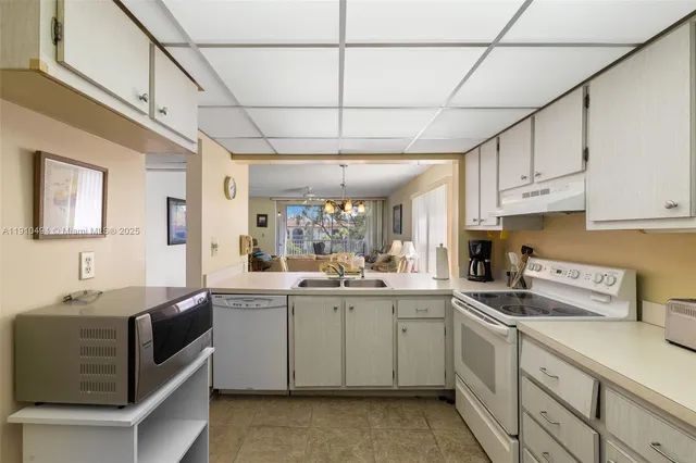 a kitchen with a sink window and cabinets