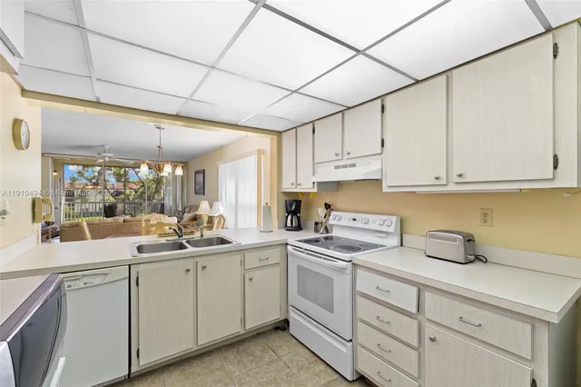 a kitchen with cabinets appliances a sink and a counter top space