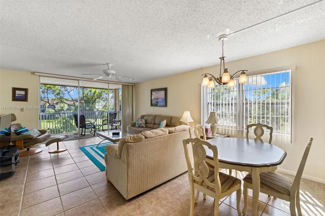 a living room with furniture a chandelier and a large window