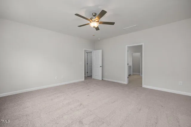an empty room with closet and ceiling fan