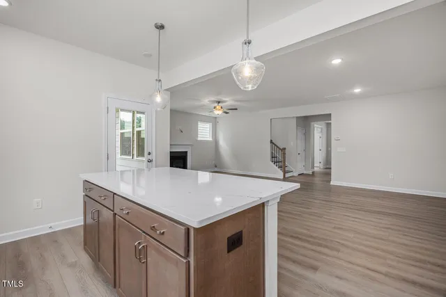 a view of a kitchen island a sink and dishwasher with wooden floor