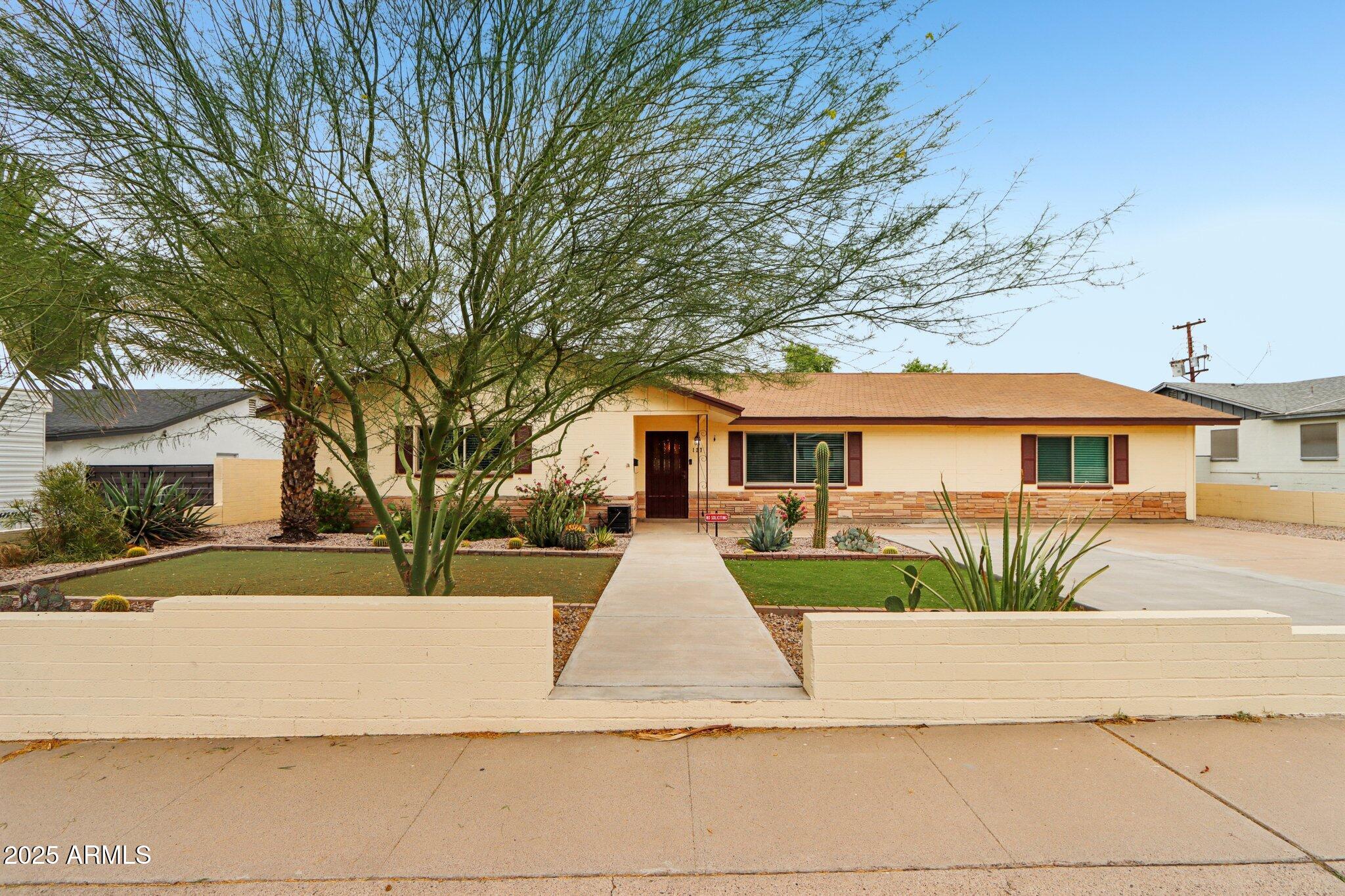 127 East Garfield Street Tempe, AZ 85288 - Photo 33 of 60 a front view of a house with a yard and potted plants