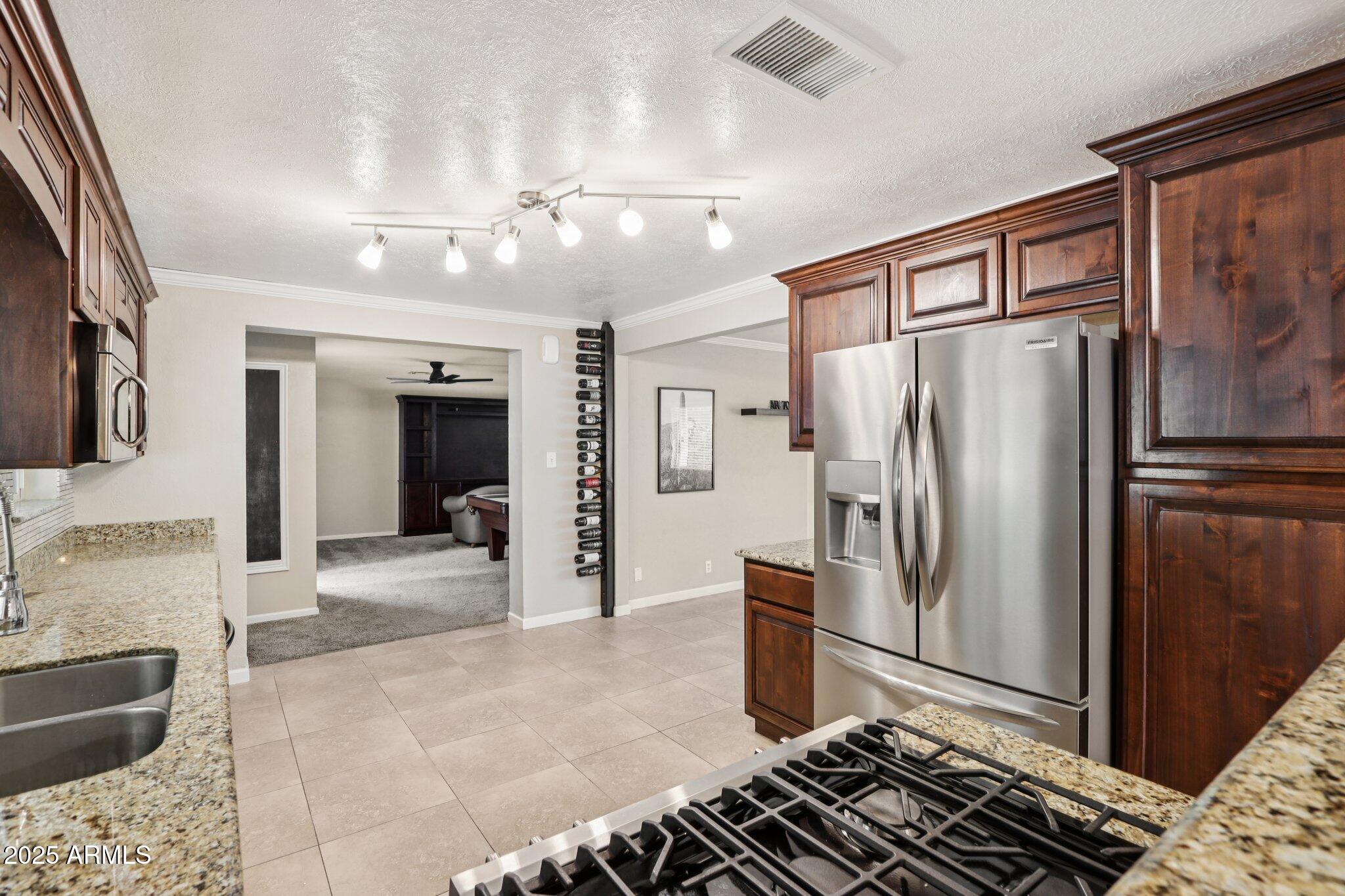 127 East Garfield Street Tempe, AZ 85288 - Photo 3 of 60 a kitchen with stainless steel appliances granite countertop a refrigerator and a sink