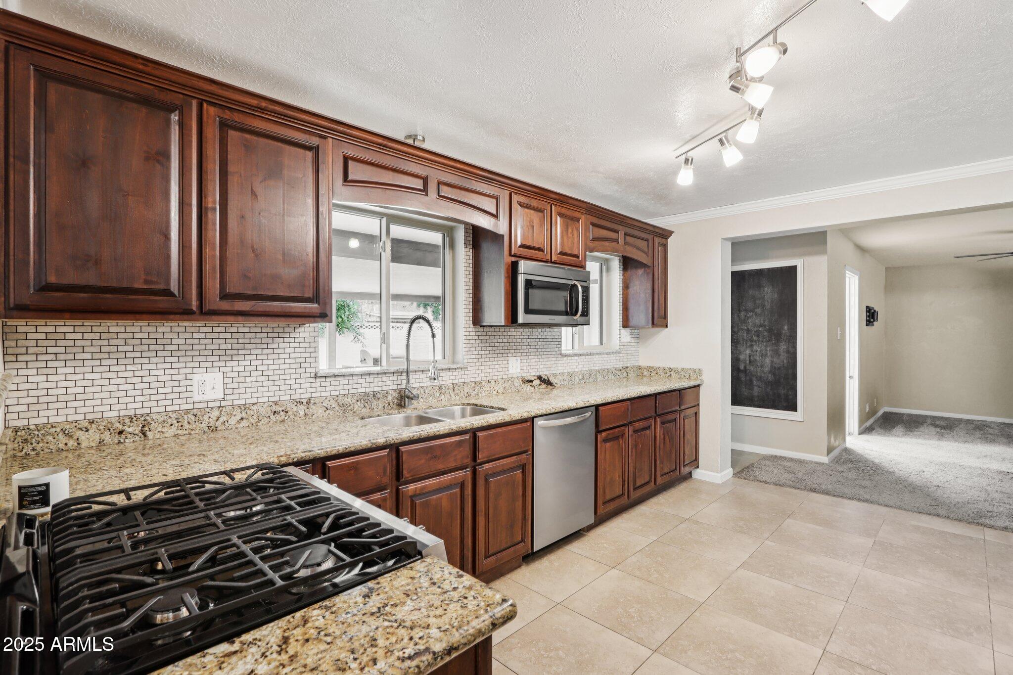 127 East Garfield Street Tempe, AZ 85288 - Photo 4 of 60 a kitchen with stainless steel appliances granite countertop a stove and a sink