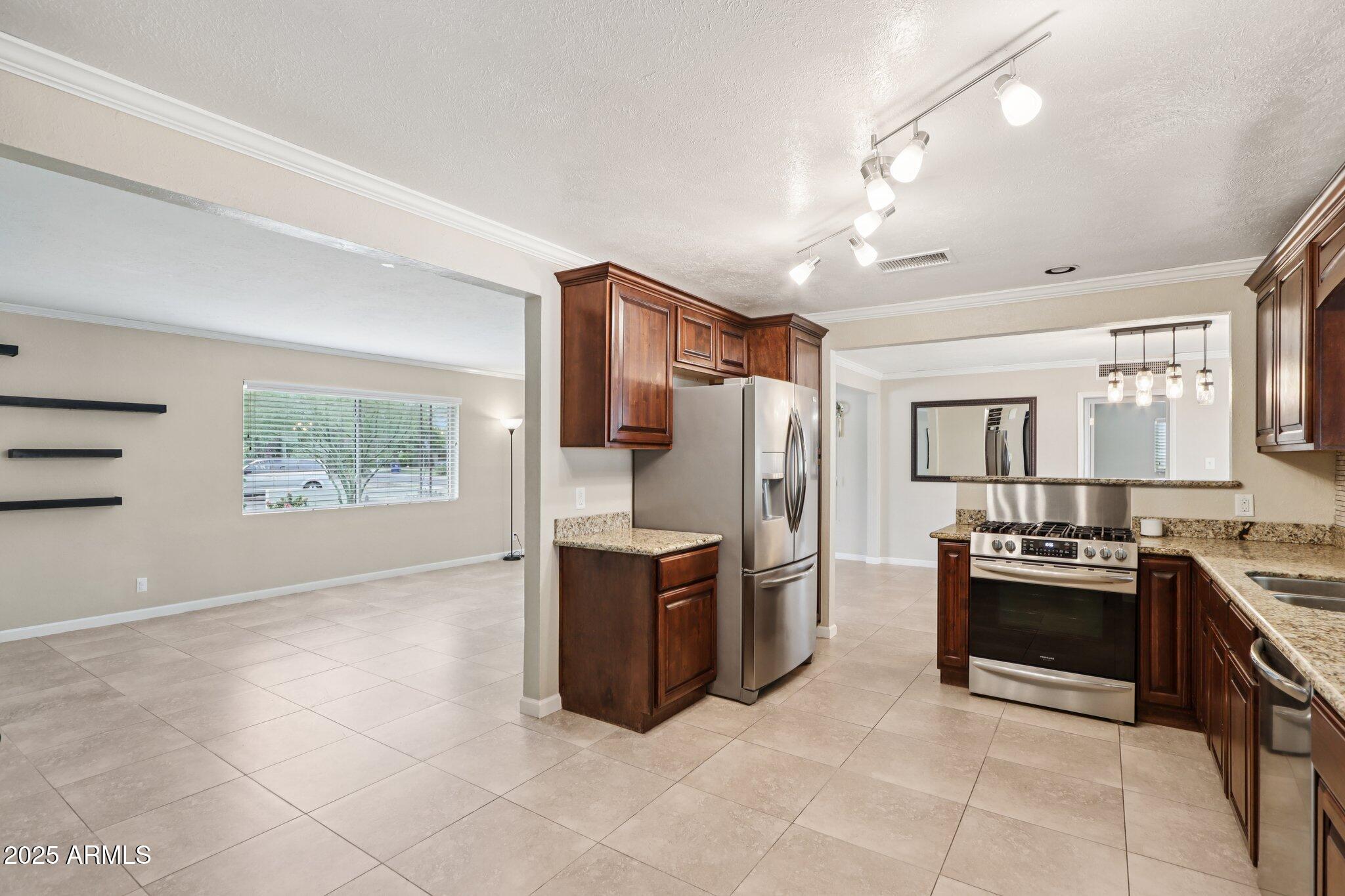 127 East Garfield Street Tempe, AZ 85288 - Photo 5 of 60 a kitchen with stainless steel appliances granite countertop a stove top oven a refrigerator a sink and dishwasher