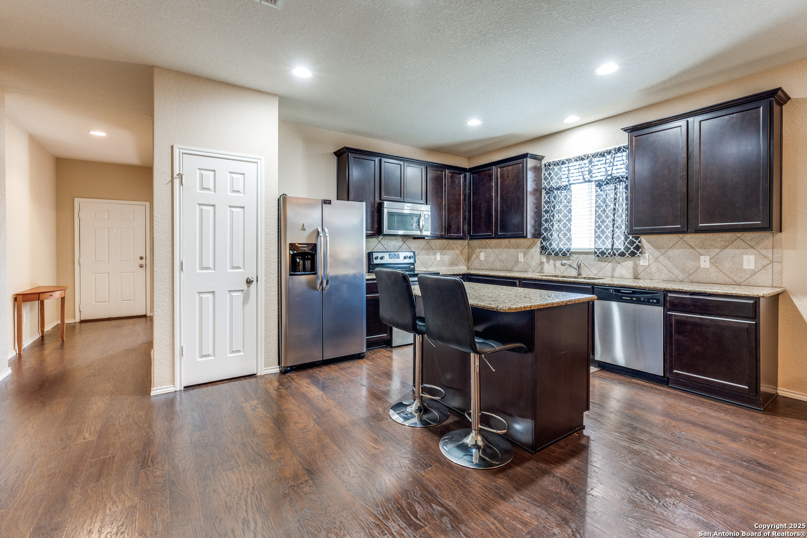 15923 Silver Rose Selma, TX 78154 - Photo 4 of 19 a kitchen with stainless steel appliances kitchen island granite countertop wooden floors and cabinets