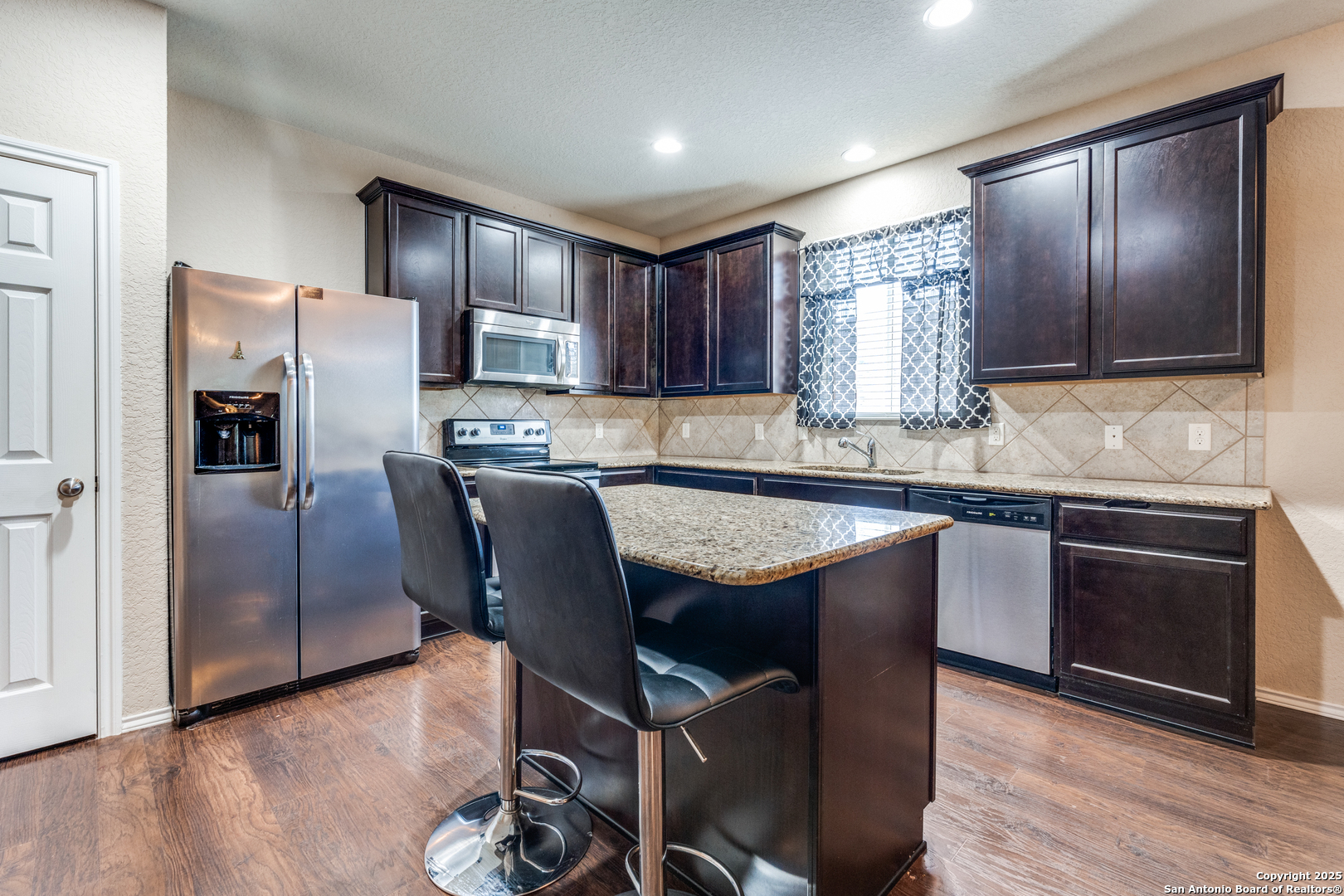15923 Silver Rose Selma, TX 78154 - Photo 6 of 19 a kitchen with granite countertop stainless steel appliances a refrigerator a stove top oven and sink