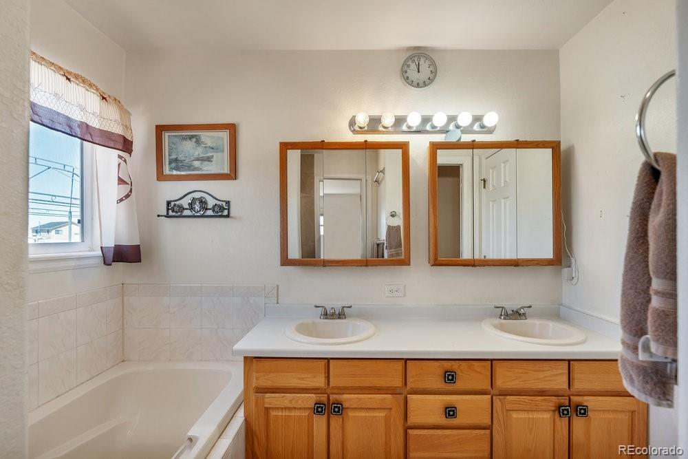 24535 County Road 5 Elbert, CO 80106 - Photo 11 of 45 a bathroom with a tub sink and mirror