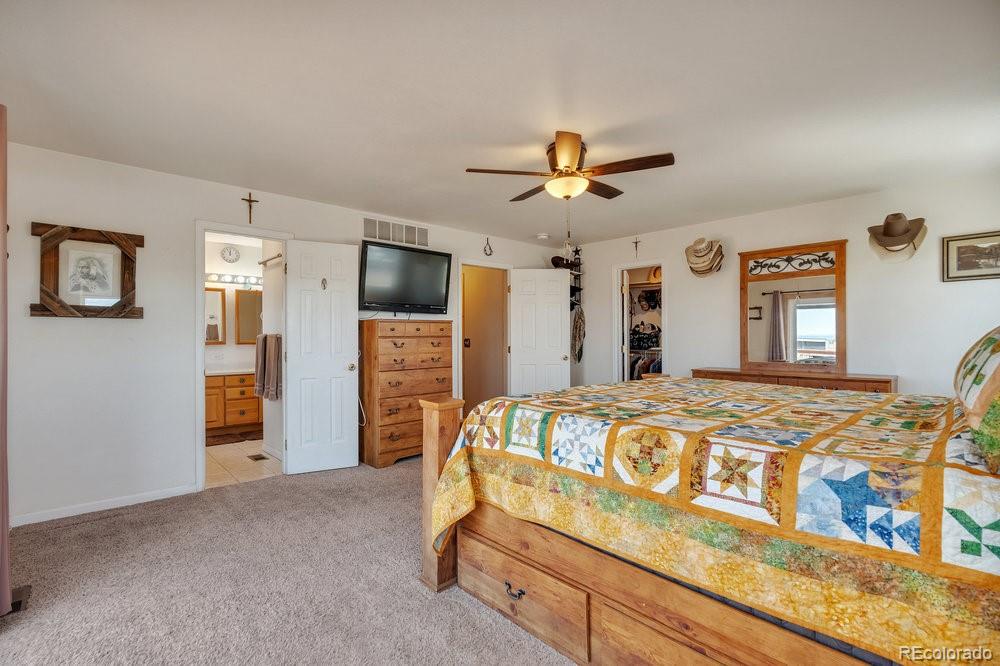 24535 County Road 5 Elbert, CO 80106 - Photo 12 of 45 a bed room with a bed and a chandelier