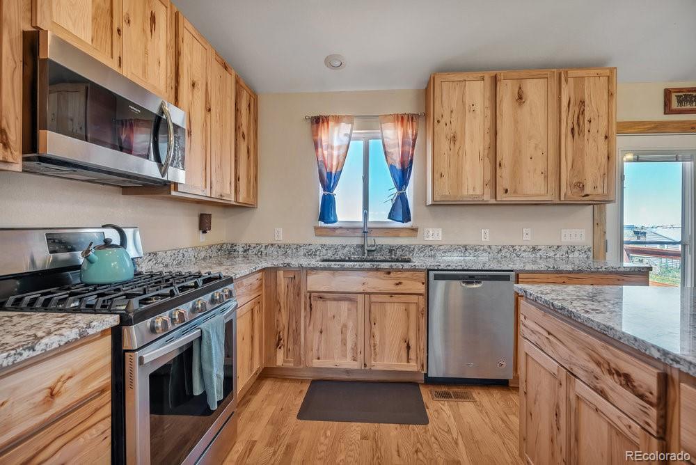 24535 County Road 5 Elbert, CO 80106 - Photo 3 of 45 a kitchen with stainless steel appliances granite countertop a stove a sink and a microwave
