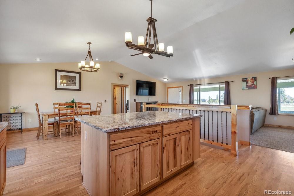 24535 County Road 5 Elbert, CO 80106 - Photo 7 of 45 a kitchen with stainless steel appliances granite countertop a kitchen island a stove and a wooden floors