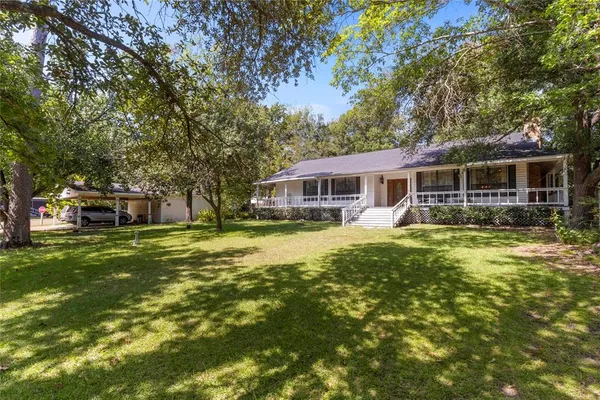 a front view of a house with a garden and trees