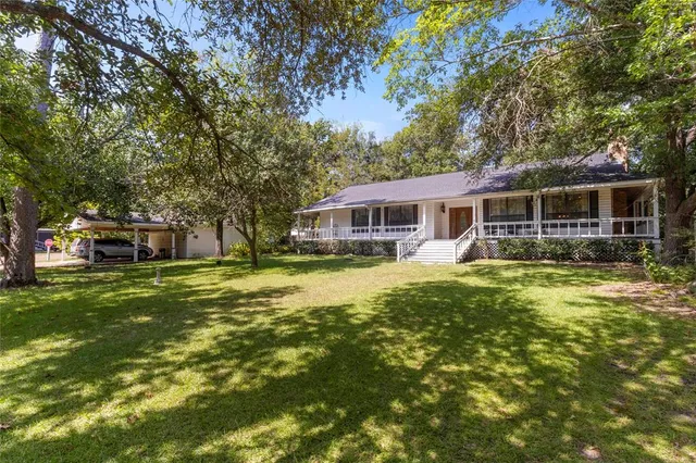 a front view of a house with a garden and trees