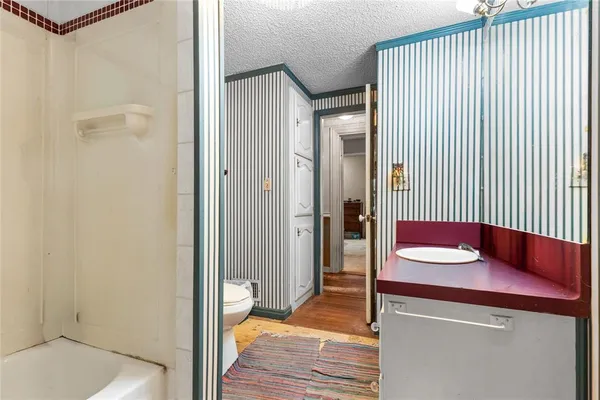 a bathroom with a sink a toilet and shower