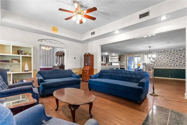 a living room with furniture a ceiling fan and a window