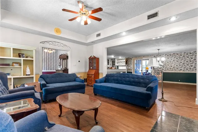 a living room with furniture a ceiling fan and a window