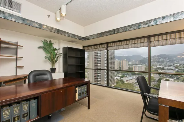 a dining room with furniture a window and a potted plant