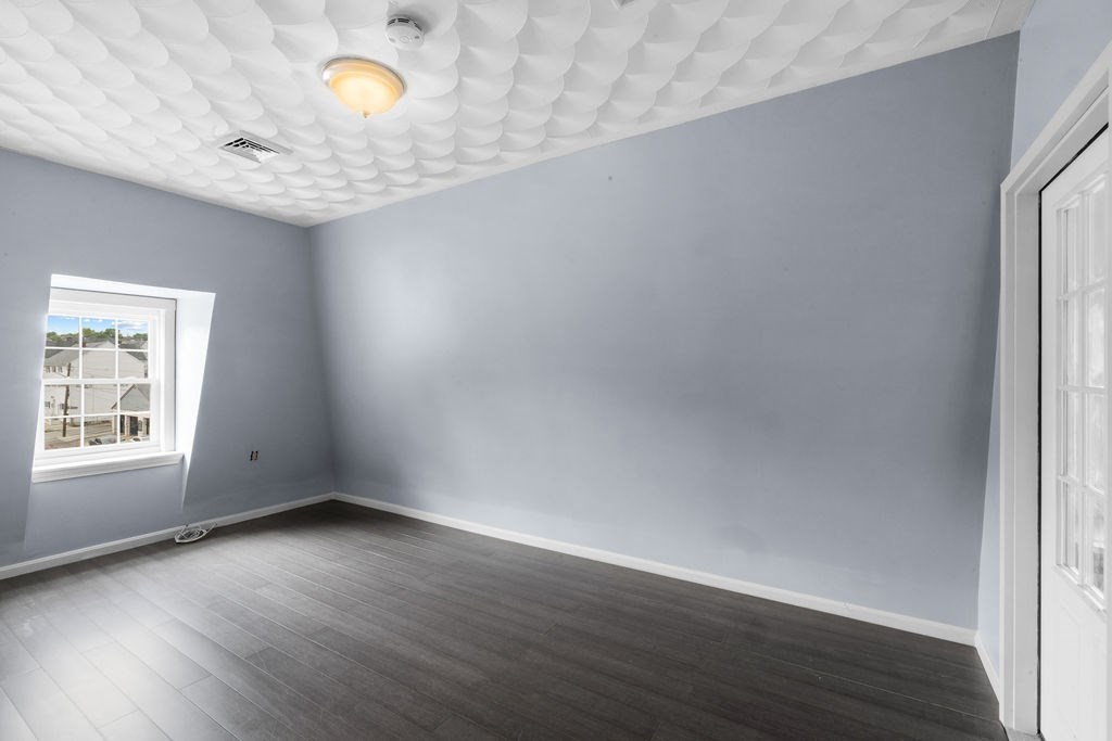 186 John Street Fall River, MA 02721 - Photo 13 of 38 an empty room with wooden floor and windows