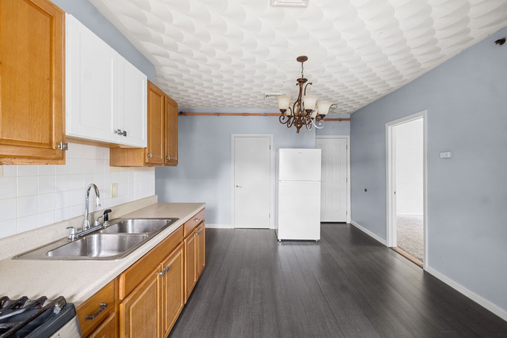 186 John Street Fall River, MA 02721 - Photo 19 of 38 a kitchen with a sink a refrigerator and chandelier