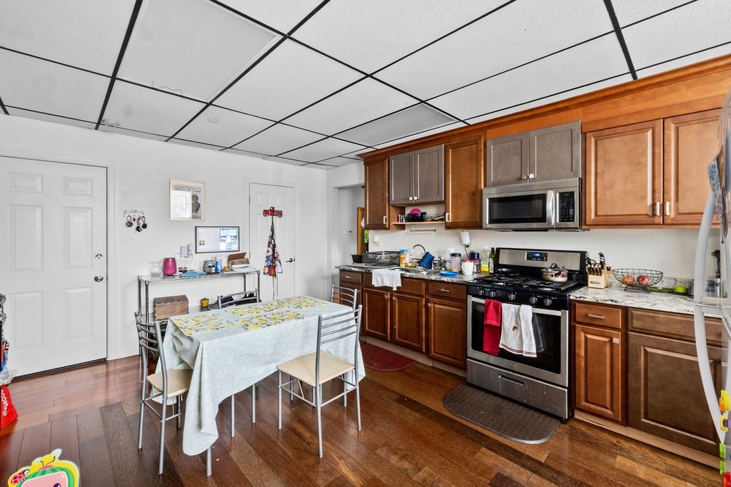 186 John Street Fall River, MA 02721 - Photo 27 of 38 a kitchen with stainless steel appliances granite countertop a stove top oven a sink dishwasher and white cabinets with wooden floor
