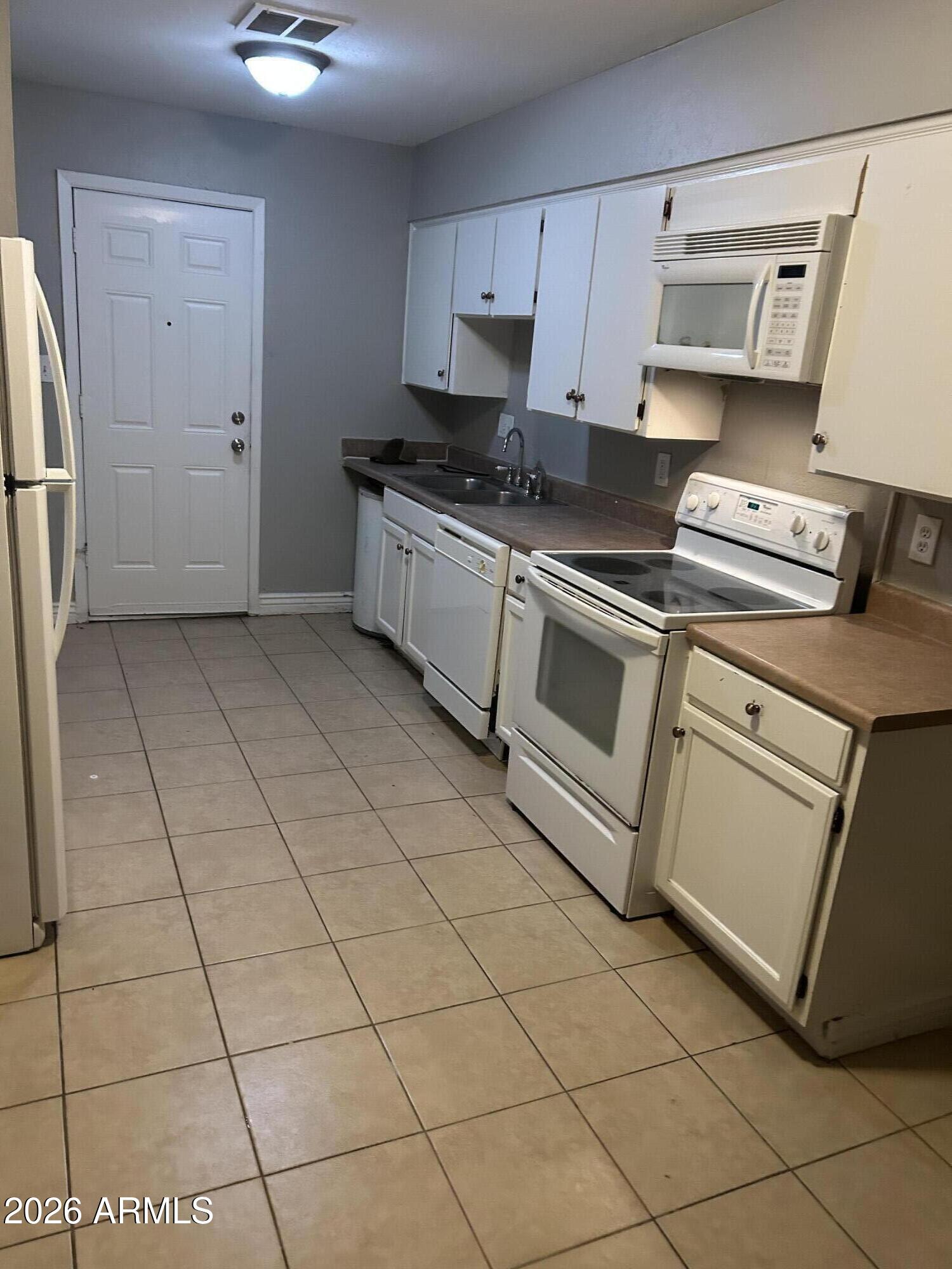 8413 East Coronado Road, Unit 3 Scottsdale, AZ 85257 - Photo 2 of 5 a kitchen with granite countertop a stove a sink and a refrigerator