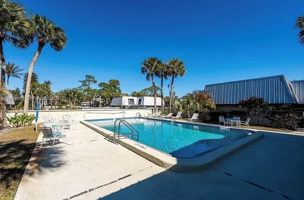 a view of a swimming pool with a patio and a yard