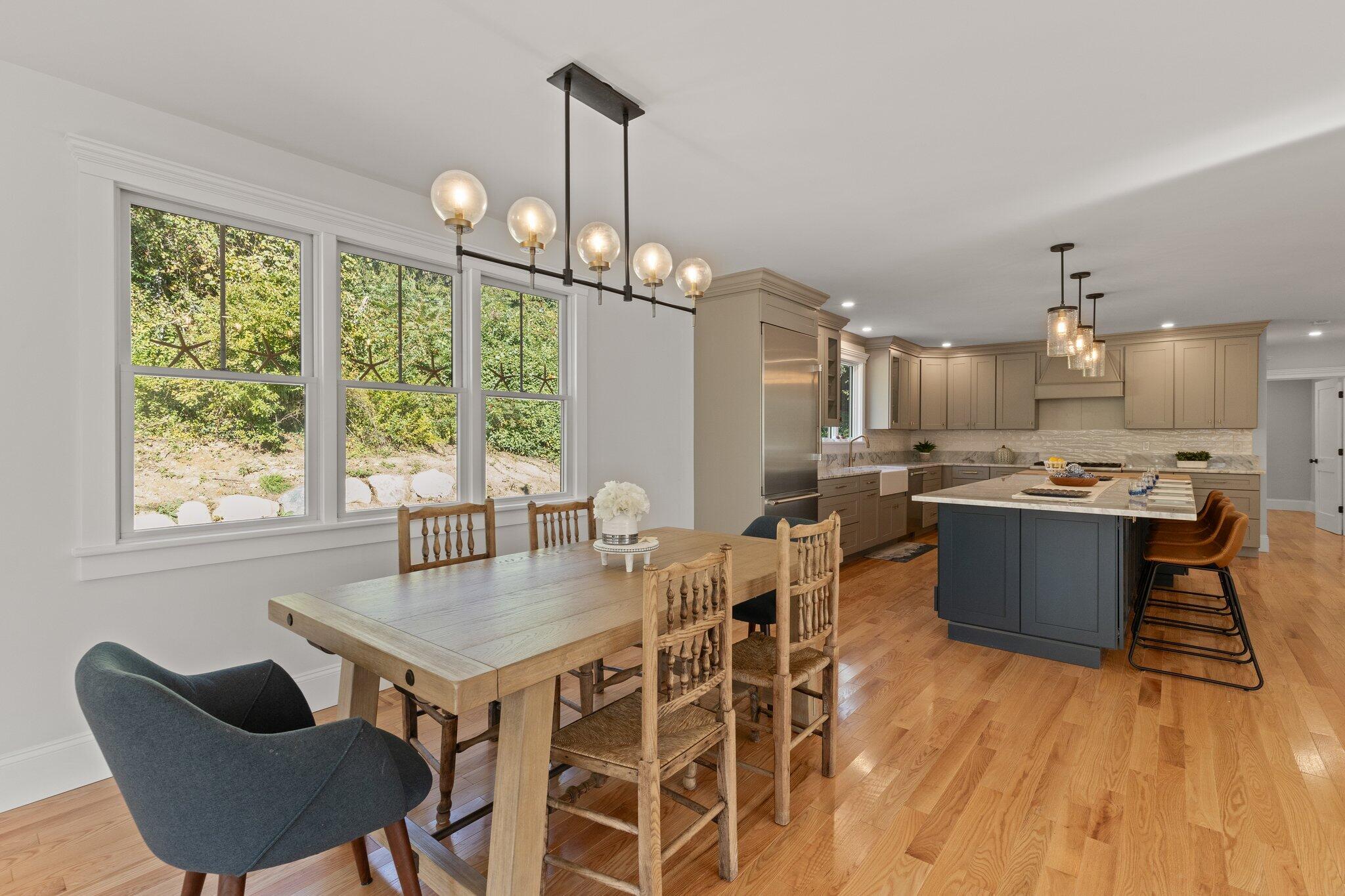 12 Jonathan Lane Sandwich, MA 02563 - Photo 15 of 57 a kitchen with stainless steel appliances granite countertop a stove a refrigerator a kitchen island a dining table and chairs with wooden floor