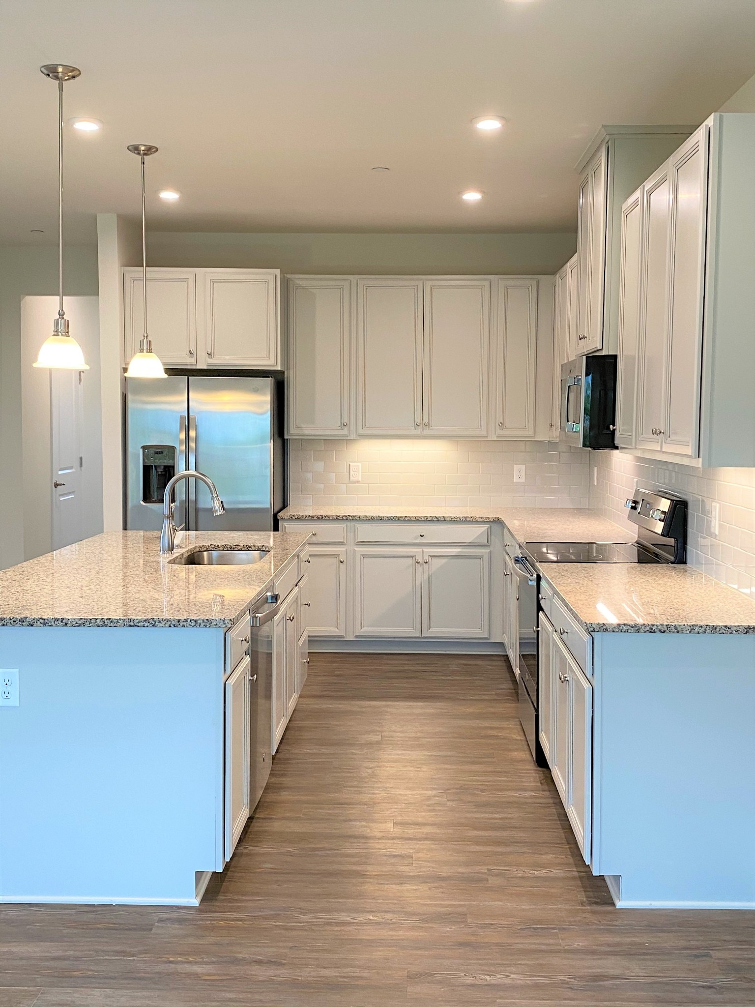 106 Keelon Gap Road, Unit 104A Spring Hill, TN 37174 - Photo 9 of 25 a large kitchen with stainless steel appliances kitchen island granite countertop a sink and cabinets