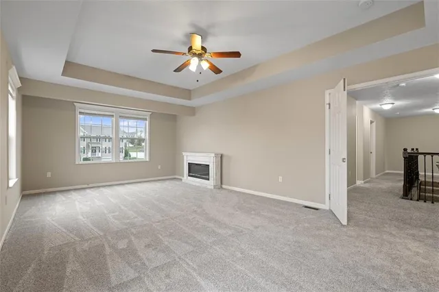 an empty room with windows and ceiling fan