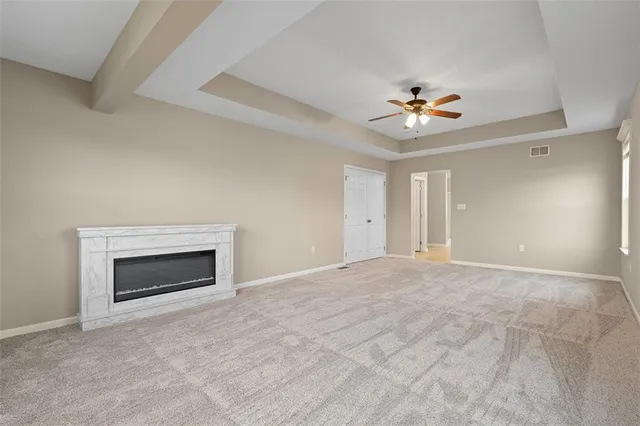 a view of an empty room with a fireplace and a window