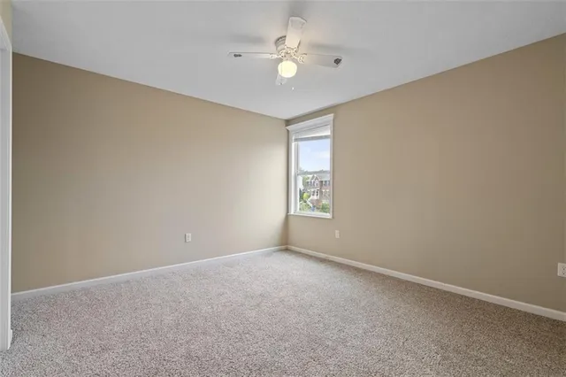 an empty room with a window and a fan