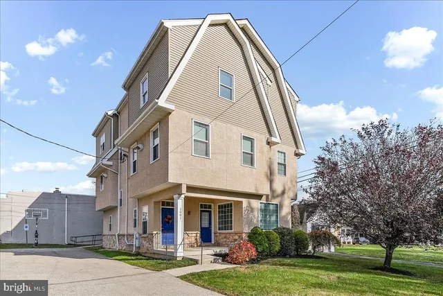 a view of a white building with a yard