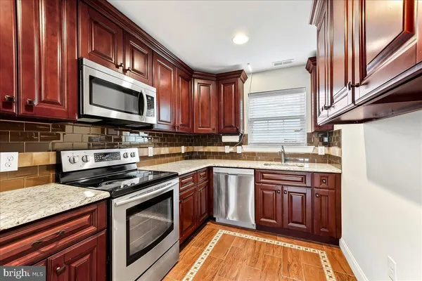 a kitchen with stainless steel appliances granite countertop a stove top oven a sink dishwasher and a microwave oven on the blue kitchen countertops