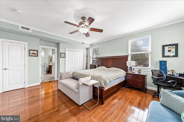 a bedroom with a bed and wooden floor