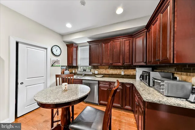 a kitchen with granite countertop a sink a stove and cabinets