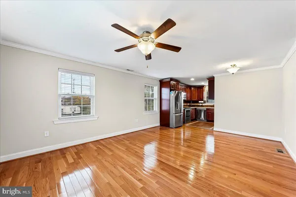 a view of an empty room with window and wooden floor