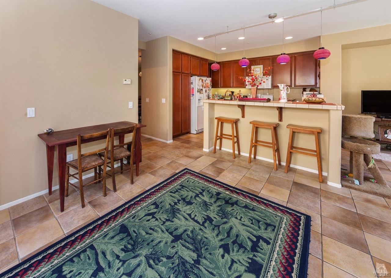 2102 Ribera Drive Oxnard, CA 93030 - Photo 7 of 18 a kitchen with stainless steel appliances granite countertop a stove top oven a dining table and chairs with wooden floor