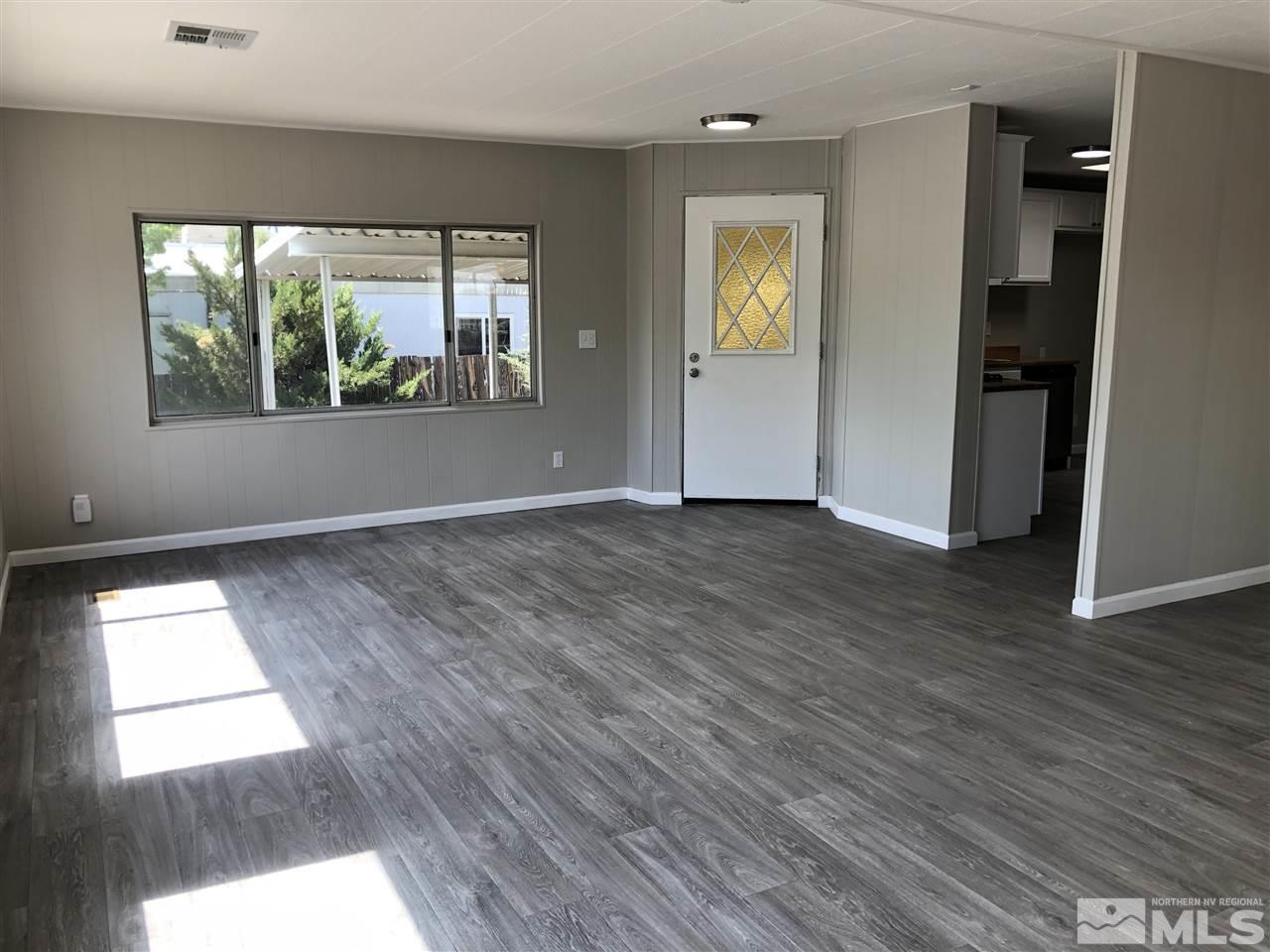 14060 Rhyolite Circle, Unit 89521 Reno, NV 89521 - Photo 3 of 18 an empty room with wooden floor and windows