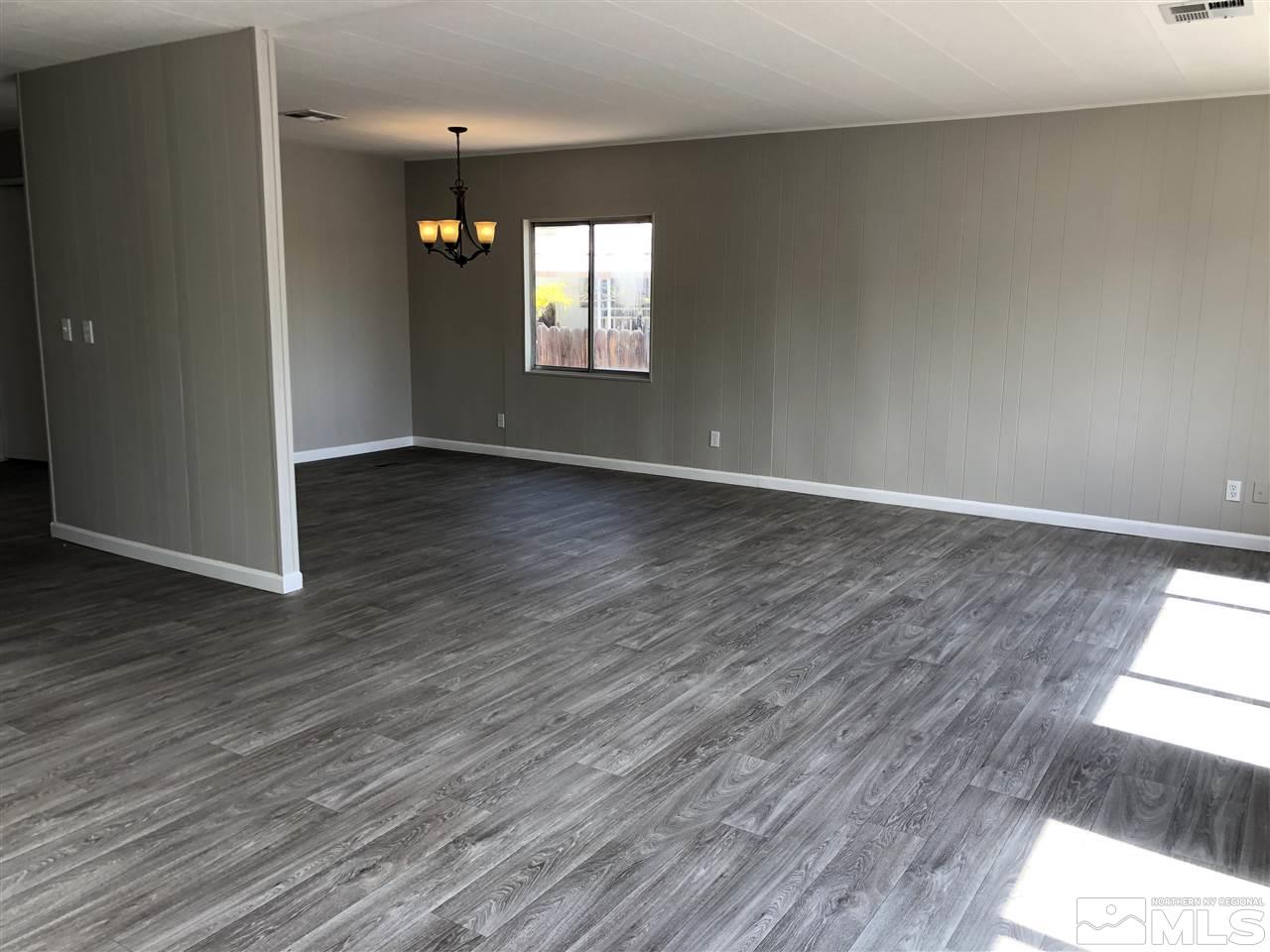 14060 Rhyolite Circle, Unit 89521 Reno, NV 89521 - Photo 4 of 18 an empty room with wooden floor and windows