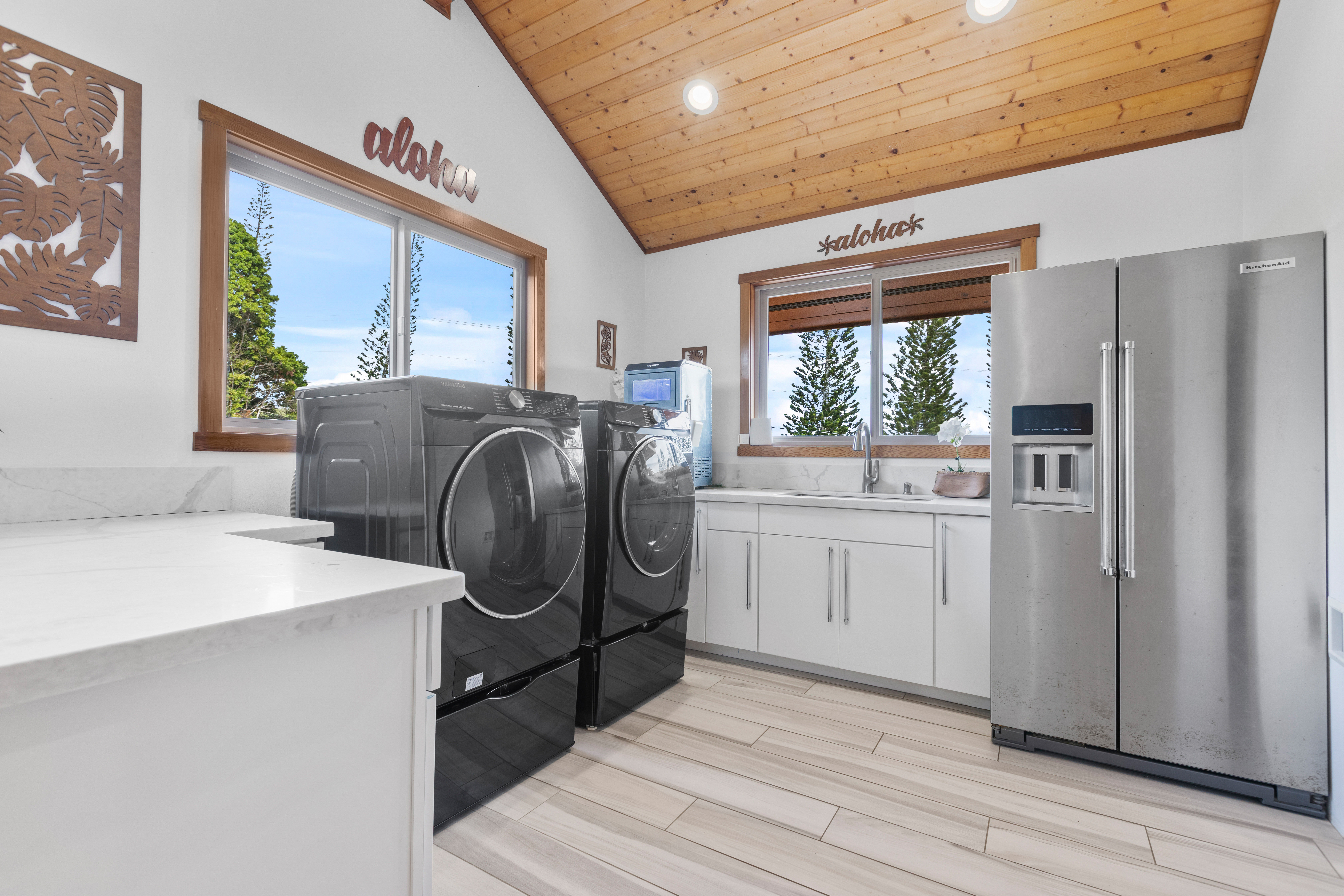 28-425 Overpass Road Pepeekeo, HI 96783 - Photo 26 of 30 a kitchen with a refrigerator a sink and dishwasher with wooden floor