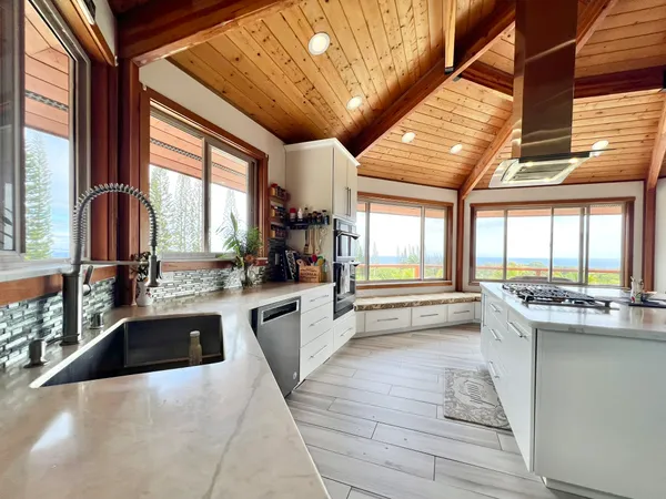 a large kitchen with kitchen island granite countertop a large window