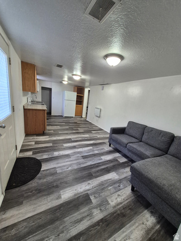 327 North 300 West Logan, UT 84321 - Photo 9 of 12 Living room featuring a textured ceiling and dark wood-type flooring