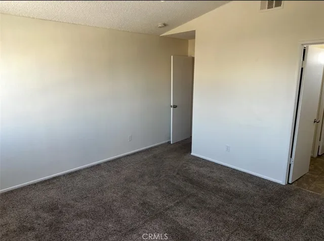 a view of a hallway with wooden floor and a bathroom