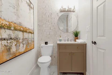 a bathroom with a toilet a sink and mirror