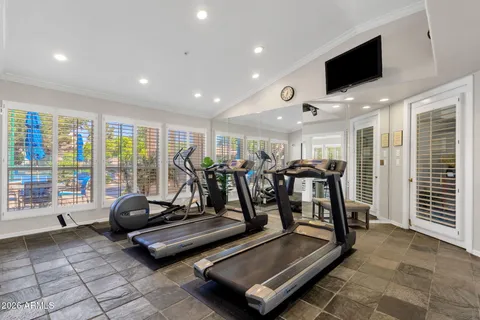 a living room with gym equipment and a flat screen tv