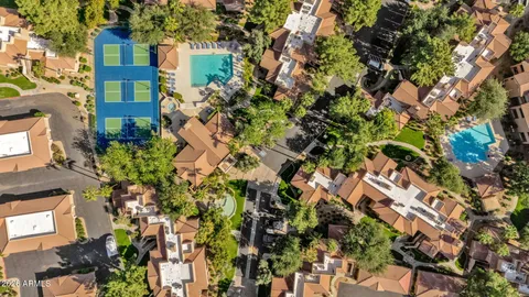 an aerial view of residential houses with outdoor space and trees