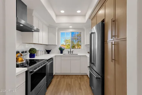a kitchen with stainless steel appliances a refrigerator sink and stove